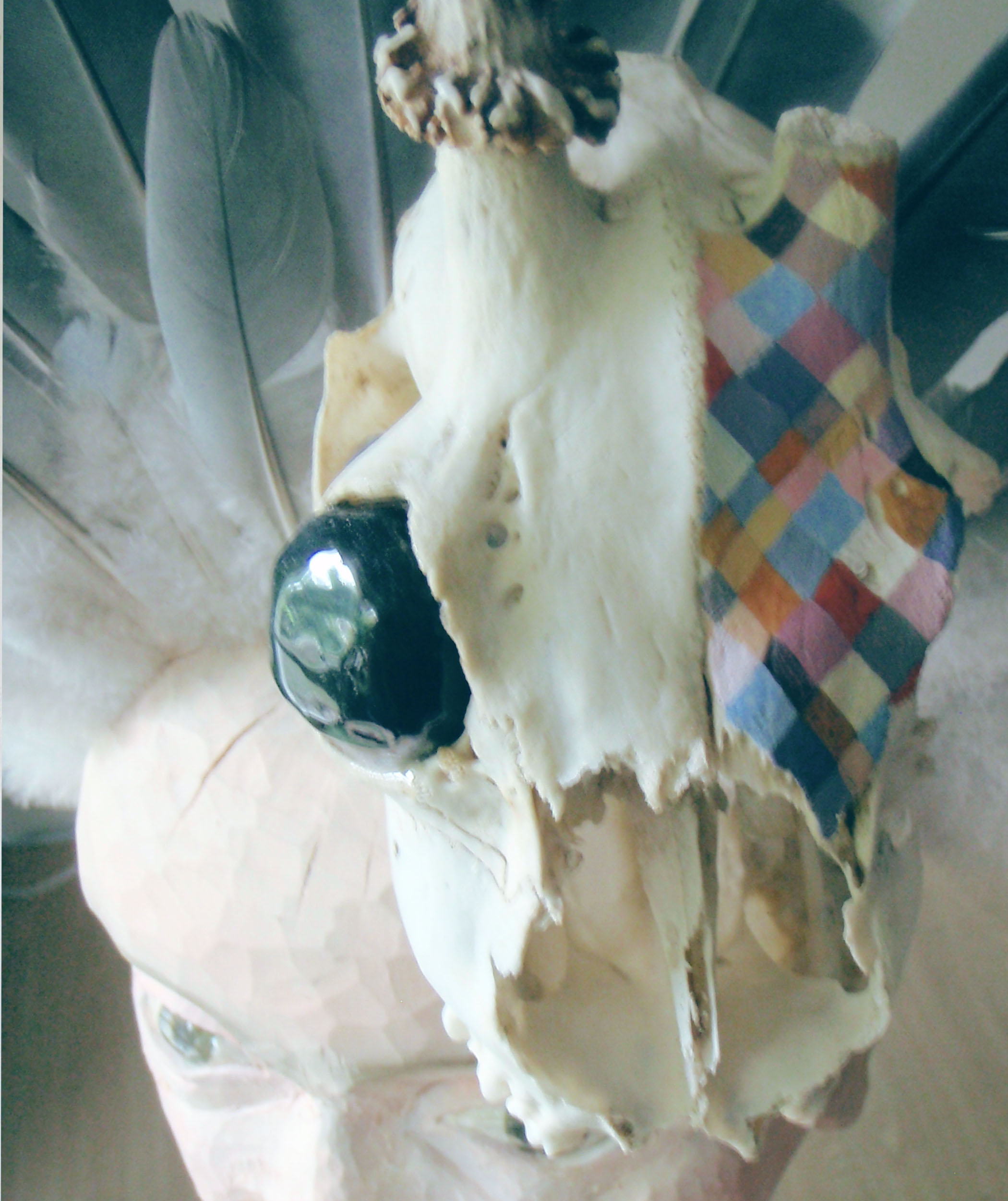 Skulptur av trä, rådjursskalle och duvfjädrar